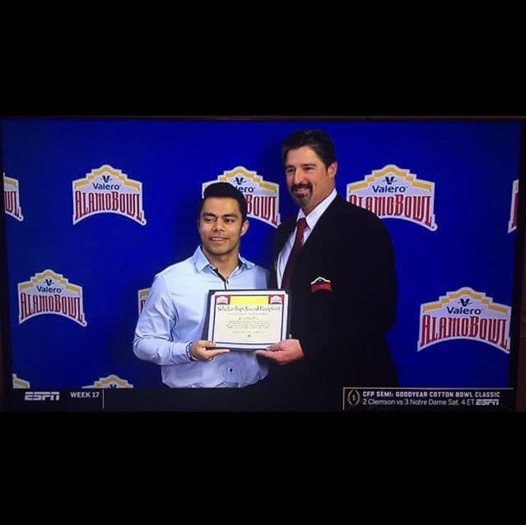 Coach Cortez receiving scholarship at the Alamo Bowl
